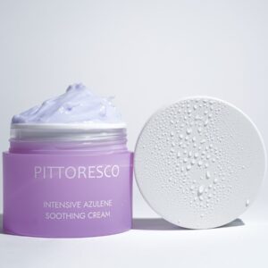 Purple jar of soothing cream with lid droplets under bright lighting. Ideal for skincare and beauty concepts.