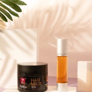 A table topped with a jar of hair mask next to a plant